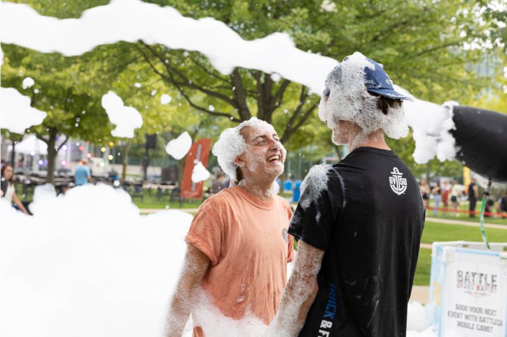 Two students standing in foam during Laker Kickoff